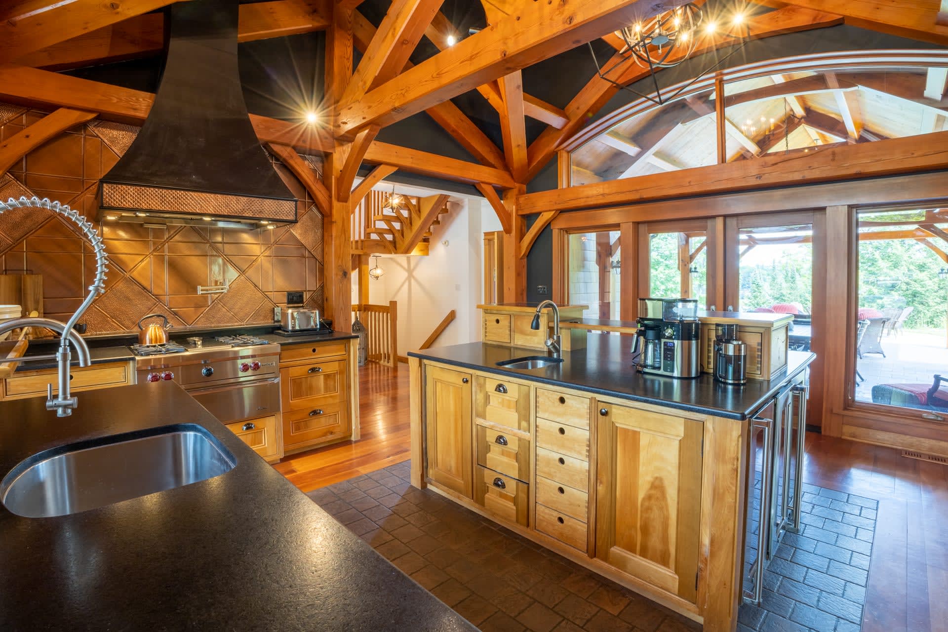 In a kitchen, wood cabinetry with black countertops face each other