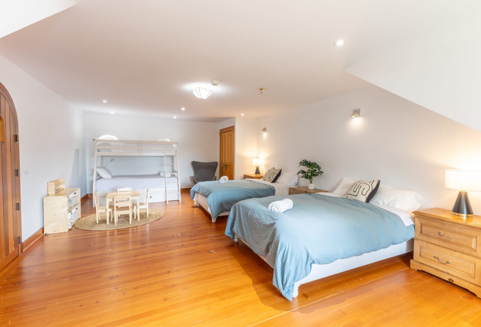 Two beds with blue covers in a white bedroom