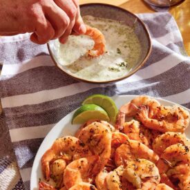 Grilled peel and eat shrimp with green goddess dip on a table