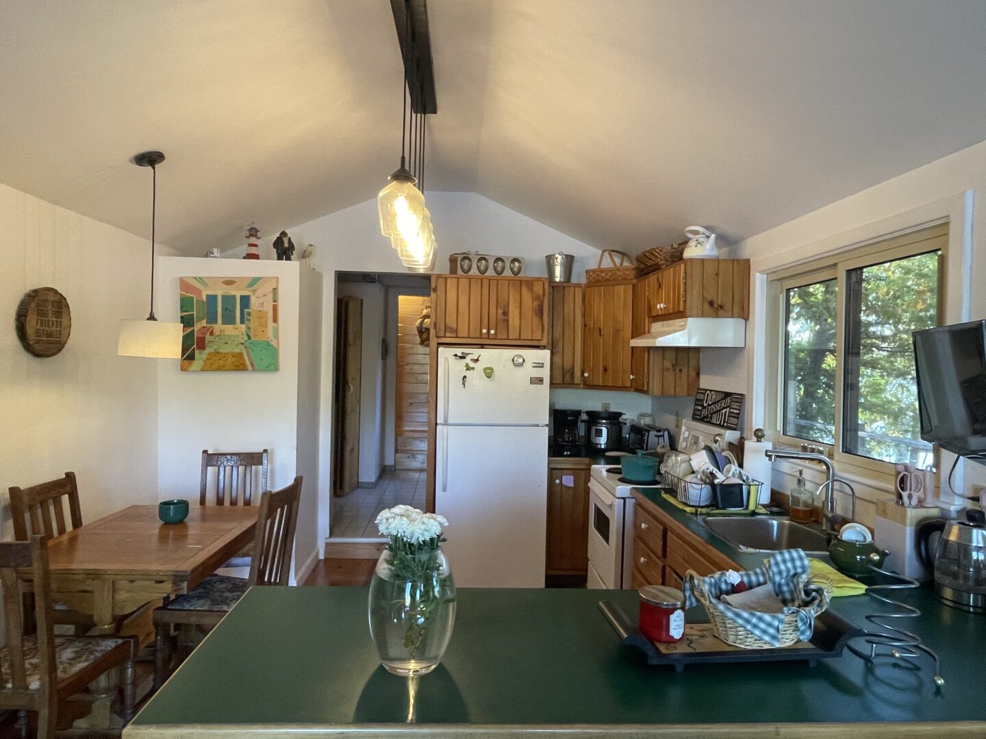 A small kitchen with green countertops and wood walls
